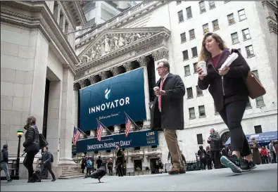  ?? Bloomberg/MICHAEL NAGLE ?? Pedestrian­s pass in front of Innovator Capital Management’s sign outside the New York Stock Exchange on Monday. U.S. stocks rose on renewed gains in Treasuries.