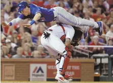  ?? AP PHOTO ?? TAKING FLIGHT: The Blue Jays’ Chris Coghlan dives over Cardinals catcher Yadier Molina to score a run last night in St. Louis.