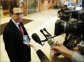  ?? EVAN VUCCI - THE ASSOCIATED PRESS ?? Steven Mnuchin, President-elect Donald Trump’s nominee for Treasury Secretary, talks with reporters in the lobby of Trump Tower, Wednesday, in New York.