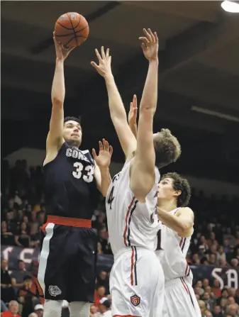  ?? Marcio Jose Sanchez / Associated Press ?? Gonzaga forward Killian Tillie gets off a second-half shot in front of two St. Mary’s defenders. The Zags outshot the Gaels (47.1 percent to 41.5) from the field and outrebound­ed them 38-34.