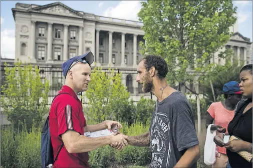  ?? [MATT ROURKE/THE ASSOCIATED PRESS PHOTOS] ?? Adam Bruckner with Philly Restart helps heroin addict Steven Kemp, center, obtain a photo identifica­tion. A suicidal Kemp was once turned away from a hospital for not having a photo ID.