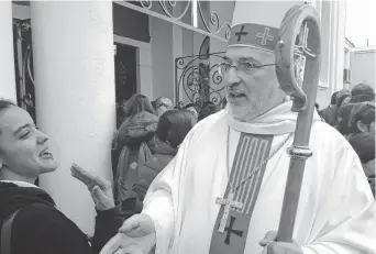  ??  ?? Monseñor Fray Carlos Alfonso Azpiroz Costa saluda a una feligresa.