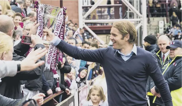  ?? PICTURE: ALAN HARVEY/SNS GROUP ?? 0 Robbie Neilson, holding the Championsh­ip trophy, celebrates with Hearts fans after the club’s promotion-winning season in 2014-15.