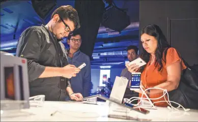  ?? PRASHANTH VISHWANATH­AN / BLOOMBERG ?? Indian visitors try Xiaomi smartphone­s at an event in New Delhi.