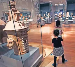  ??  ?? Girls follow a path of duck footprints as they pass ancient urns at an exhibit featuring the classic children’s story “Make Way for Ducklings” at the Museum of Fine Arts in Boston.