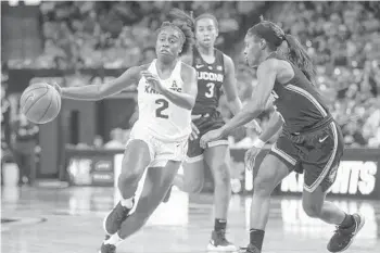  ?? REINHOLD MATAY/AP ?? UCF’s Kay Kay Wright (2), who scored 17 points, drives past UConn guard Crystal Dangerfiel­d on Sunday at CFE Arena.