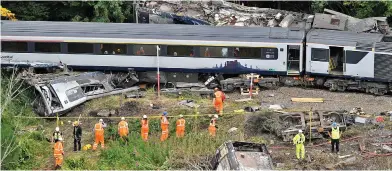  ??  ?? Tragedy: Rescue workers at the scene after derailment