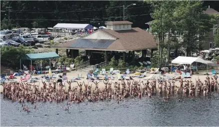  ?? BETTINA HANSEN, THE HARTFORD COURANT ?? These beach-goers at the Solair Recreation League nudist resort in North Woodstock, N.Y., are hardly camera-shy.