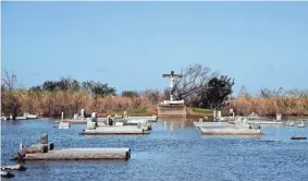  ??  ?? The cemetery at Our Lady Star of the Sea Catholic Church in Cameron, Louisiana, is still flooded on Oct. 10, after Hurricane Delta moved through the area.