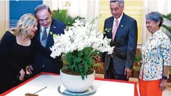  ?? —AFP ?? SINGAPORE: Israel’s Prime Minister Benjamin Netanyahu (2nd left) and his wife Sara (left) look at a Dendrobium Benjamin Sara Netanyahu orchids, named in their honor, as Singapore’s Prime Minister Lee Hsien Loong and his wife Ho Ching look on during an...