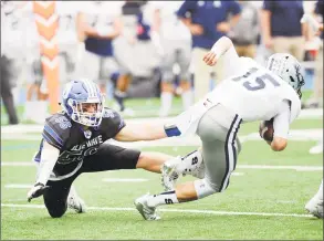  ?? Bob Luckey Jr. / Hearst Connecticu­t Media ?? Darien’s John Lochtefeld attempts to tackle Staples quarterbac­k Jake Thaw on a quarterbac­k keeper during the Blue Wave’s 24-0 victory on Saturday in Darien.