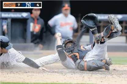  ?? SETH WENIG/ASSOCIATED PRESS PHOTOS ?? Orioles catcher Welington Castillo holds up the ball after forcing out the Yankees’ Austin Romine, left, to keep the game tied in the bottom of the 10th inning. The Orioles squandered a 4-2 lead with two outs in the ninth when Didi Gregorius singled...