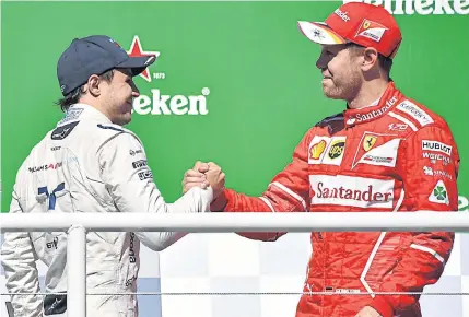  ?? AFP ?? Brazilian Grand Prix champion Sebastian Vettel of Ferrari, right, is congratula­ted by Williams driver Felipe Massa on the podium.