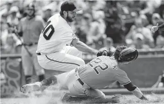  ?? Scot Tucker / Associated Press ?? Giants pitcher Madison Bumgarner tags Josh Reddick out at home after a pitch got away in the sixth.