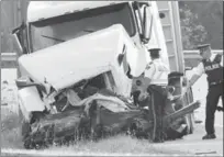  ?? JOHN RENNISON, THE HAMILTON SPECTATOR ?? OPP officers survey the front of the transport truck that was hit head on by the car on Highway 6 Thursday morning.