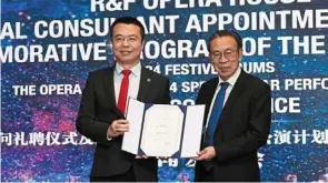  ?? ?? tan (right) receiving his appointmen­t letter as Permaisuri Zarith Sofiah Opera house cultural consultant from Lee.