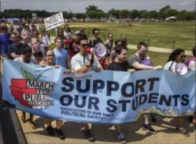  ?? BILL O’LEARY / WASHINGTON POST ?? Led by Steve Ciprani, center left, and Pavithra Nagarajan, right, hundreds of activists march toward the Education Department building in the District on Saturday.