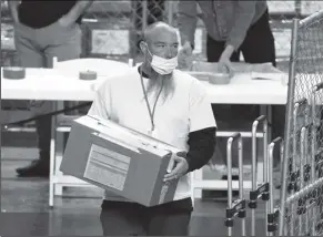  ?? ROB SCHUMACHER/THE ARIZONA REPUBLIC VIA AP ?? A BOX OF MARICOPA COUNTY BALLOTS cast in the 2020 general election are delivered to be examined and recounted by contractor­s working for Florida-based company Cyber Ninjas at Veterans Memorial Coliseum in Phoenix on April 29.