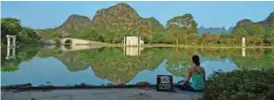  ??  ?? A woman meditates beside a lake at Club Med's resort.