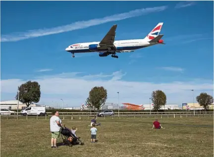  ??  ?? Taking a hit: Onlookers watch as a passenger aircraft, operated by British Airways, a unit of IAG lands at London Heathrow Airport in London. IAG expects pilot strikes to cost the company 137 million euros. — Bloomberg