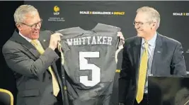  ?? RICARDO RAMIREZ BUXEDA/STAFF FILE PHOTO ?? Dr. Dale Whittaker receives a football jersey from Marcos Marchena, Chairman of the University of Central Florida Board of Trustees during his introducti­on March 9.
