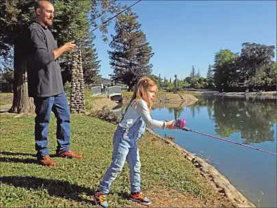  ??  ?? Anthony Furr and daughter Layla, 4, cast lines hoping for a bite at the Fishing Derby at Ellis Lake on Saturday.