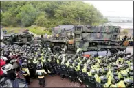  ?? AP/KIM JUN-BUM ?? North Korean leader Kim Jong Un (left) joins anniversar­y festivitie­s Wednesday at Wonsan, North Korea. At right, South Korean police officers block protesters Wednesday as U.S trucks haul equipment for a missile-defense system at Seongju. Officials...