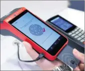  ?? REUTERS ?? A representa­tive demonstrat­es how to register a fingerprin­t on an electronic credit card at a stand during an expo in Las Vegas, Nevada.