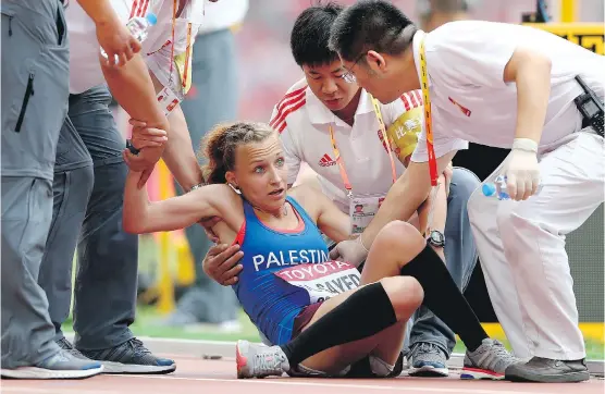  ?? GETTY IMAGES/ FILES ?? A competitor collapses in exhaustion after crossing the marathon finish line at the IAAF World Athletics Championsh­ips. Self-talk can be key in endurance races.