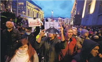  ?? DIMITAR DILKOFF AFP VIA GETTY IMAGES ?? Opposition supporters hold signs as they attend a rally in support of jailed Kremlin critic Alexei Navalny Wednesday in Moscow. Nearly 1,500 people were arrested at rallies across Russia.