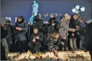  ?? AP/PAVEL GOLOVKIN ?? People light candles Tuesday at Pushkin square in Moscow to commemorat­e the victims of a fire in a shopping mall in the Siberian city of Kemerovo.