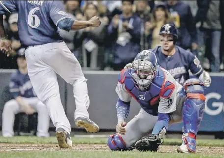  ?? Robert Gauthier Los Angeles Times ?? DODGERS CATCHER Yasmani Grandal fails to field a throw home on a Manny Pina sacrifice fly. That allowed runners to move up to second and third in the third inning in Game 1 of the NLCS. He also allowed a passed ball and drew an interferen­ce call in the inning.