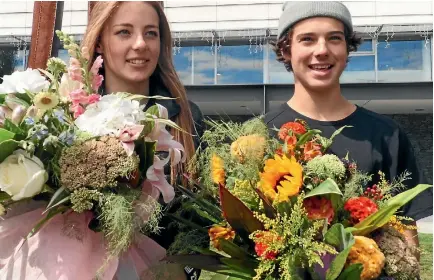  ?? PHOTO: DASHA KUPRIENKO/ STUFF ?? Wanaka-based Olympians Zoi Sadowski-Synnott and Nico Porteouswe­re are welcomed by dozens of supporters and fans after they landed at Queenstown Airport yesterday.