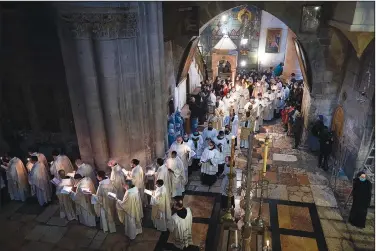  ?? (AP/Oded Balilty) ?? Priests participat­e Sunday in the Easter Mass led by the Latin Patriarch at the Church of the Holy Sepulchre, where many Christians believe Jesus was crucified, buried and rose from the dead, in the Old City of Jerusalem.