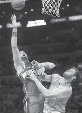  ?? Kyusung Gong Associated Press ?? THE LAKERS’ Andrew Bogut plays tight defense against the Wizards’ Marcin Gortat as he releases a shot. Gortat had 14 rebounds and 11 points Wednesday.