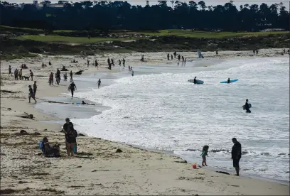  ?? DAVID ROYAL — MONTEREY HERALD CORRESPOND­ENT ?? People line the water’s edge at Asilomar Beach in Pacific Grove on Friday.