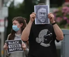  ??  ?? CALLING FOR CHANGE: Matt Laurence alongside his daughter Sophie holds signs and the likeness of George Floyd during a funeral procession for Floyd, Ahmaud Arbery and Breonna Taylor.