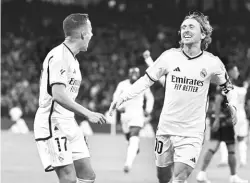  ?? — Gambar AFP ?? RAI: Modric (kanan) meraikan gol kemenangan bersama rakan sepasukan pada perlawanan La Liga Sepanyol di antara Real Madrid dan Sevilla di stadium Santiago Bernabeu di Madrid, kelmarin.
