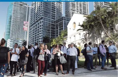  ?? JOE RAEDLE TNS ?? People wait outside after evacuating office buildings in Miami after an earthquake struck south of Cuba on Tuesday.