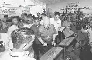  ?? — Gambar Bernama ?? TANDATANGA­N: Najib menandatan­gani satu daripada 12 plak projek Kementeria­n Kesihatan di Pulau Pinang pada Majlis Balik Pulau Bersama Perdana Menteri di Sekolah Menengah Kebangsaan Seri Balik Pulau di Balik Pulau semalam.