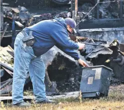  ?? STAFF PHOTOS BY DAN HENRY ?? Top: Investigat­ors search Monday for clues in the Sunday blaze that killed six in Chattooga County. Above: Fire Investigat­or Jerry Parrish takes photos at the scene.