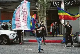  ?? Damian Dovarganes / Associated Press ?? Frankie Barcenas, left, shows his support for Black Lives Matter with a decorated transgende­r pride flag on the fourth anniversar­y of the Pulse massacre.