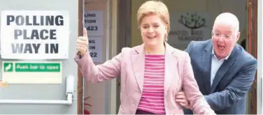  ?? Agence France-presse ?? ↑ Nicola Sturgeon (left) and husband Peter Murrell come out of a polling booth after casting their vote in local elections in Glasgow on Thursday.