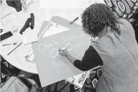  ?? Lynsey Weatherspo­on / New York Times ?? Tiffany Green-Abdullah makes a sign earlier this month in Atlanta, where black and Latino charter school supporters rallied against Democratic candidates who are backing away from charter schools.