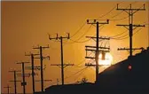  ?? Patrick T. Fallon AFP via Getty Images ?? THE SUN sets behind power lines during a heat wave in Los Angeles on Sept. 6.