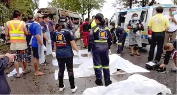  ??  ?? Police and rescue personnel surround the bodies of the migrant workers at the site of the accident. — Bernama photo