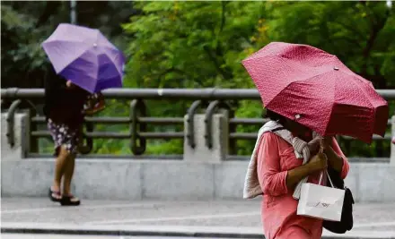  ?? Aloisio Mauricio/Fotoarena/Agência O Globo ?? Paulistano­s se protegem da chuva na sexta (5); domingo terá precipitaç­ões em diversas capitais