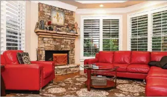  ?? TEXT BY SHANNON DOMINY. PHOTO BY REYNOLDS ROGERS. ?? A sectional, chair and coffee table from Value City create a cozy setup in the keeping room of Martha and Jean- Francois Morizur’s Cumming home. The wooden fireplace screen carved with goats and mountains is from Bonneval- sur- Arc, France, which is one of Jean- Francois’ favorite places in France, where he and his parents would vacation when he was young.