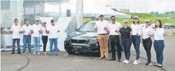  ??  ?? (From third right) Josephine, Jolene, Wang and Gavin in front of the marquee tent showroom set up at Stadium Perpaduan for the BMW Performanc­e Day this weekend.