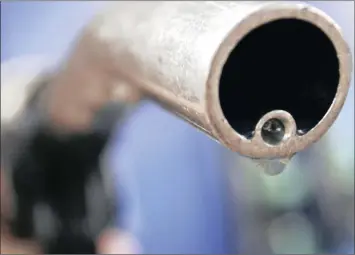  ?? PHOTO: REUTERS ?? A motorist holds a fuel pump at a petrol station. The Mineral Petroleum Resources Developmen­t Act has been delayed.